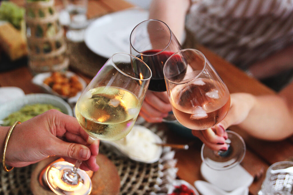 Französischer Wein und Käse auf einem Holztisch im Sonnenlicht